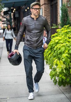 Laid-back: Ryan Reynolds showed off his casual style in a chic, brown leather jacket, dark wash jeans, and low-top sneakers while out in New York City on Monday